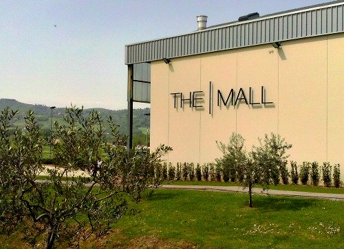 Exterior of The Mall, surrounded by rolling hills and olive trees