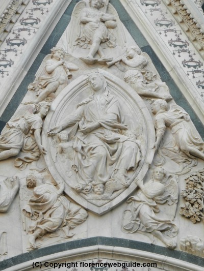 The almond shaped oval which gives the door its name, with the relief with image of Mary ascending to the heavens